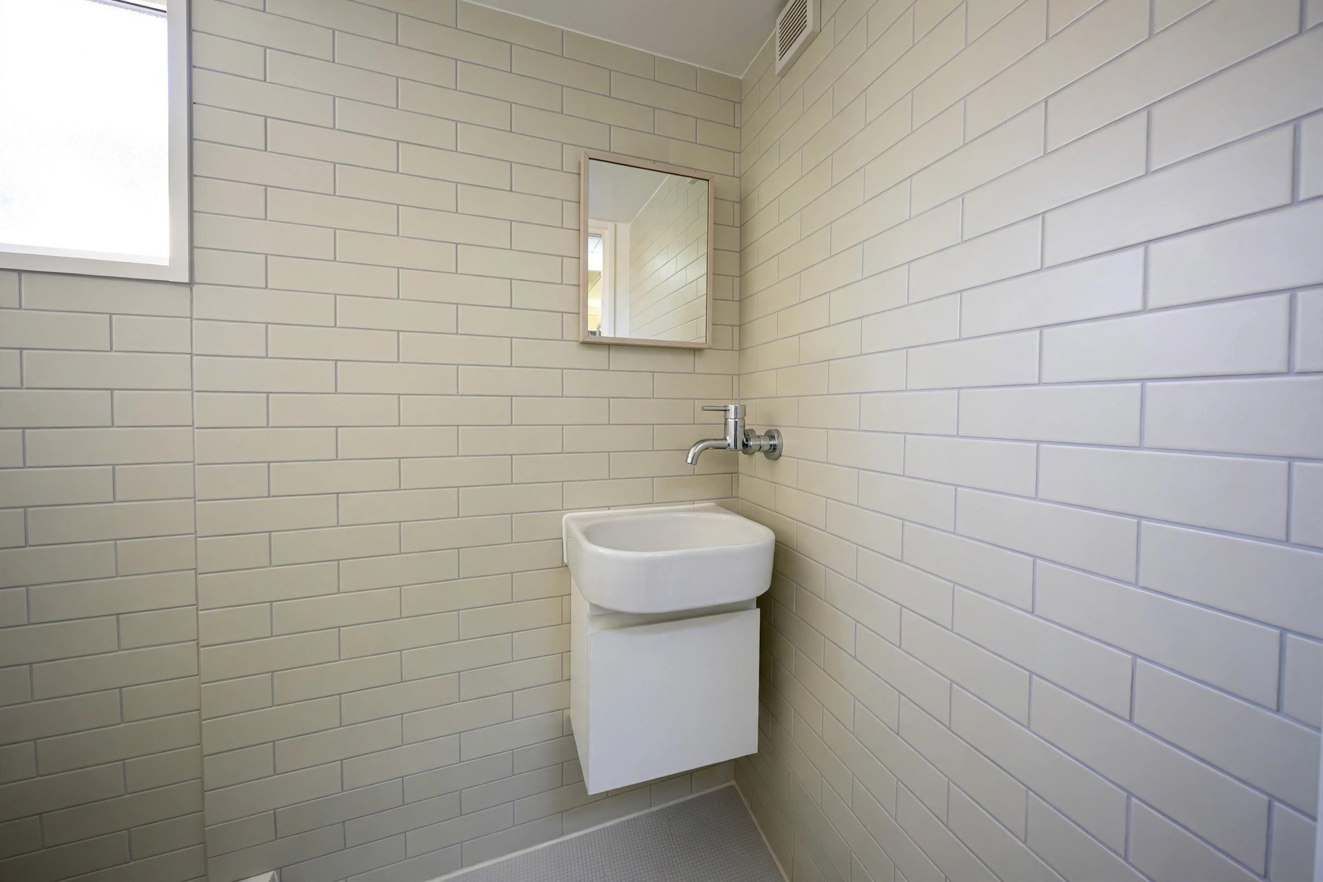 Compact rounded basin on a slim vanity in a small bathroom