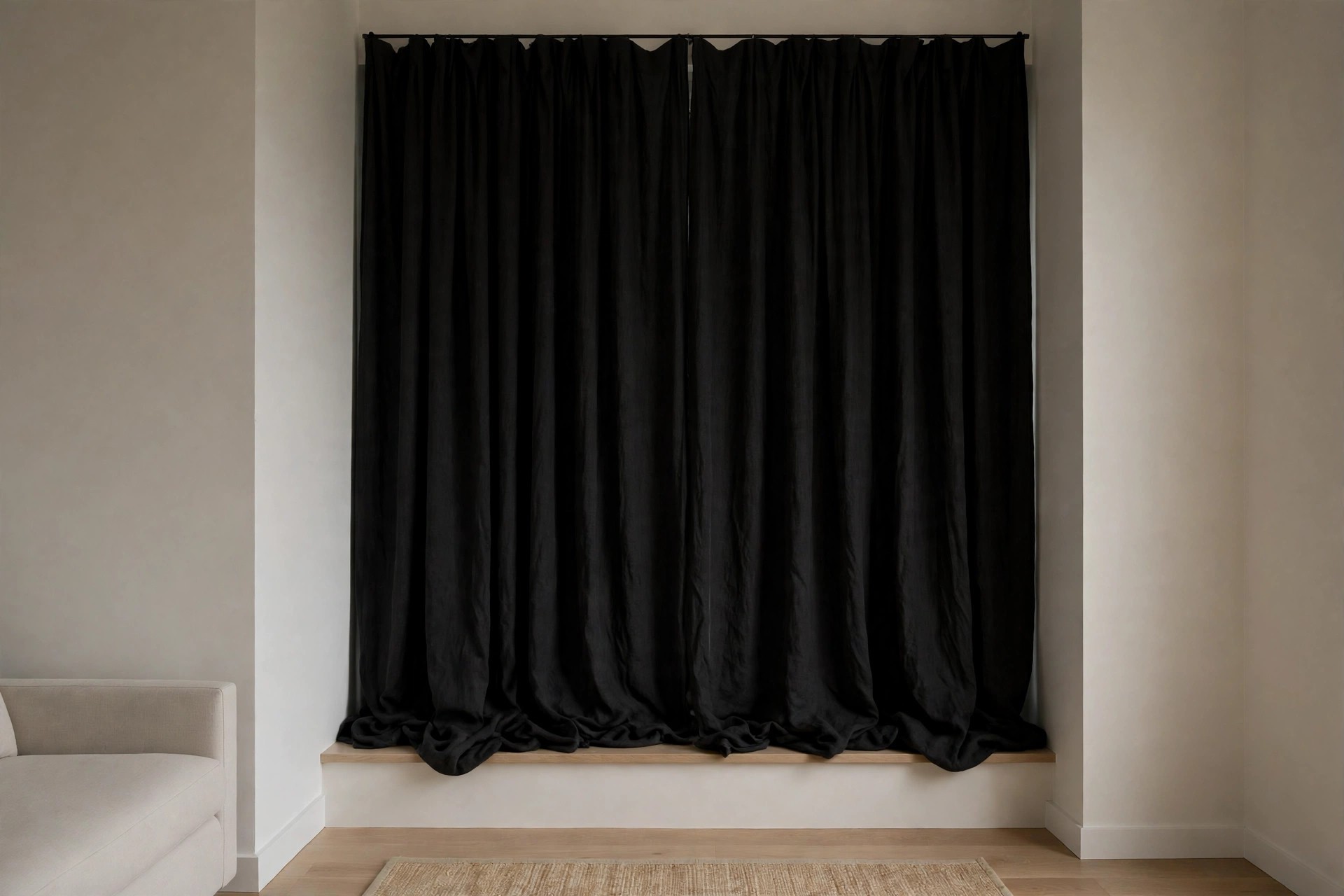 Heavy dark curtains drawn closed over a living room window beside a light sofa